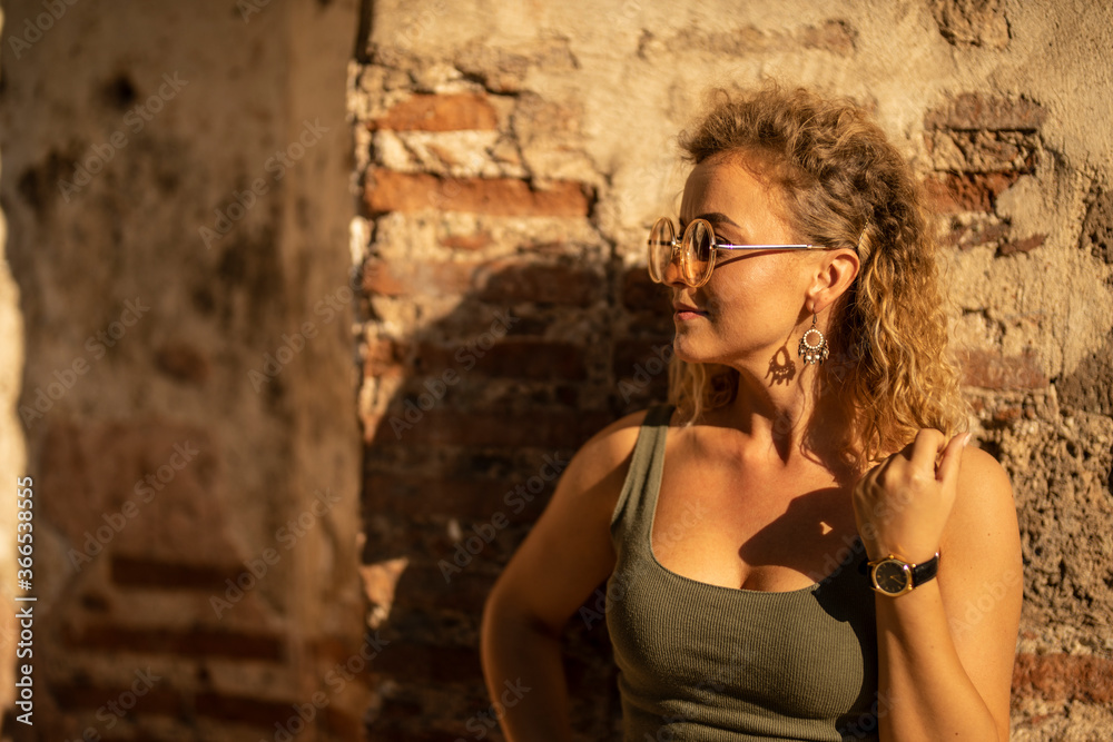 Obraz premium Young woman posing in front of ruined old wall