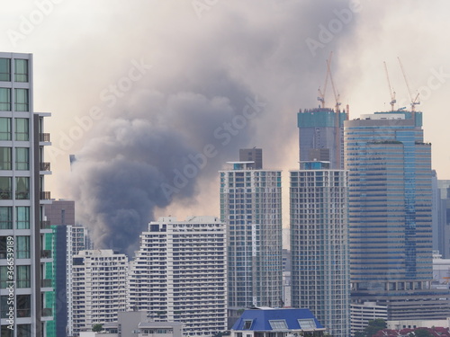 Black smoke caused by a fire in a downtown Bangkok building, Danger from using electricity or broken electrical wires, Selective focus.