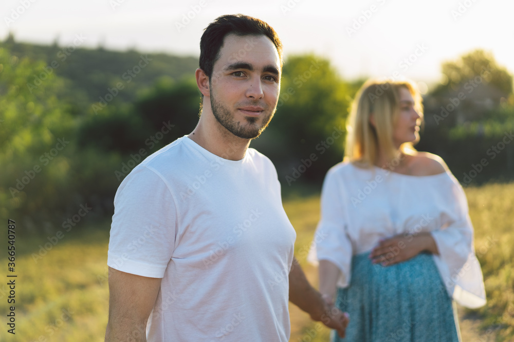 Obraz premium Happy and young pregnant couple in outdoors