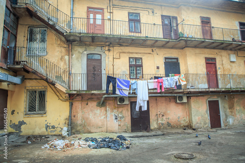 old inner courtyard with different clothes drying on balcony in historical Lviv city