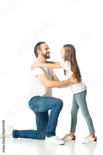 side view of father hugging happy daughter isolated on white