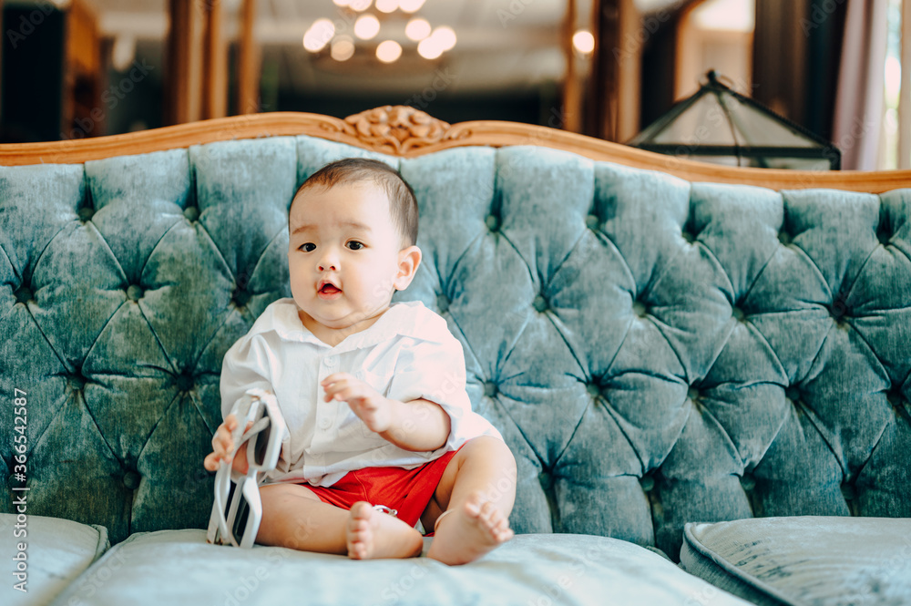 Asian baby sitting on sofa, summer fashion concept Asian baby sitting on sofa, summer fashion concept