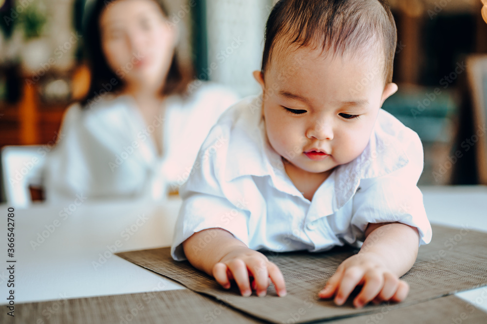Mom is talking on the mobile phone a spending time with her baby boy at home Mom is talking on the mobile phone a spending time with her baby boy at home