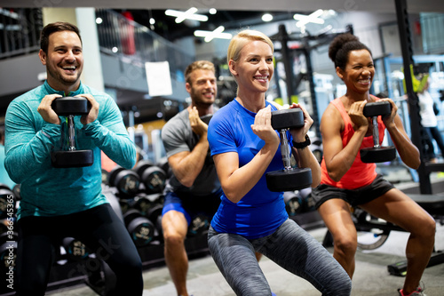 Attractive sports people friends are working out in gym