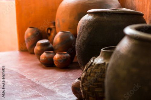Traditional pottery, a group of jars and gourds on a tiled floor.