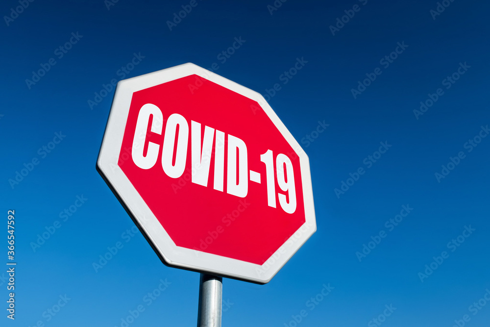 A stop traffic sign to block spreading COVID-19 disease with blue sky A stop traffic sign to block spreading COVID-19 disease with blue sky