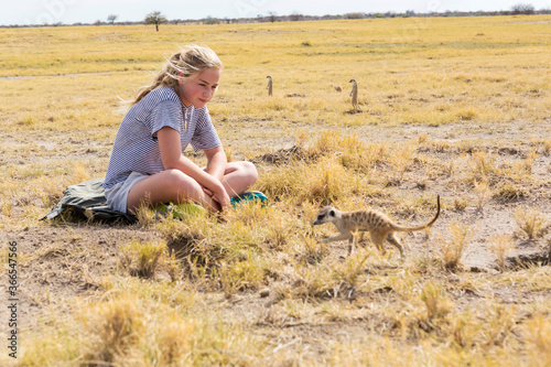 12 year old girl looking at Meerkats, Kalahari Desert, Makgadikgadi Salt Pans, Botswana photo