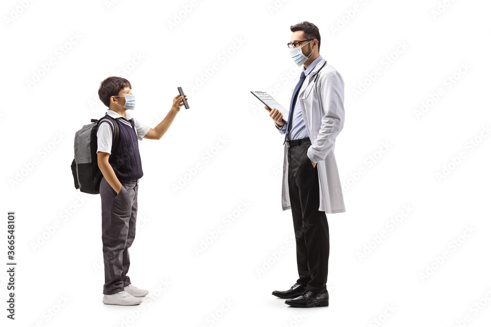 Schoolboy wearing a protective face mask and showing a mobile phone to a doctor Schoolboy wearing a protective face mask and showing a mobile phone to a doctor