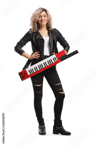Full length portrait of a female musician with a keytar synthesizer