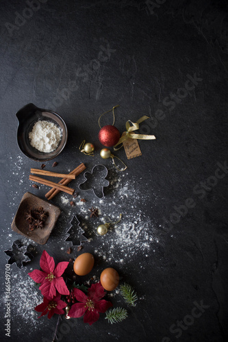 Christmas Baking Ingredients on Black Table, Christmas Flatlay on Dark Background with Copy Space. Christmas Cake Ingredients Top Down Shot