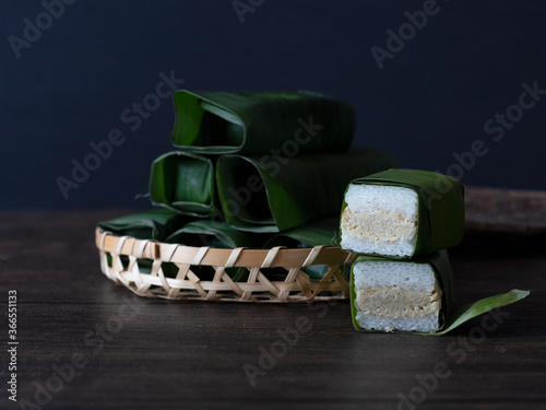 Lemper, Indonesian Snack Glutinuous Rice Wrapped in Banana Leaves. Indonesian Tamales against Dark Background with Copy Space. photo