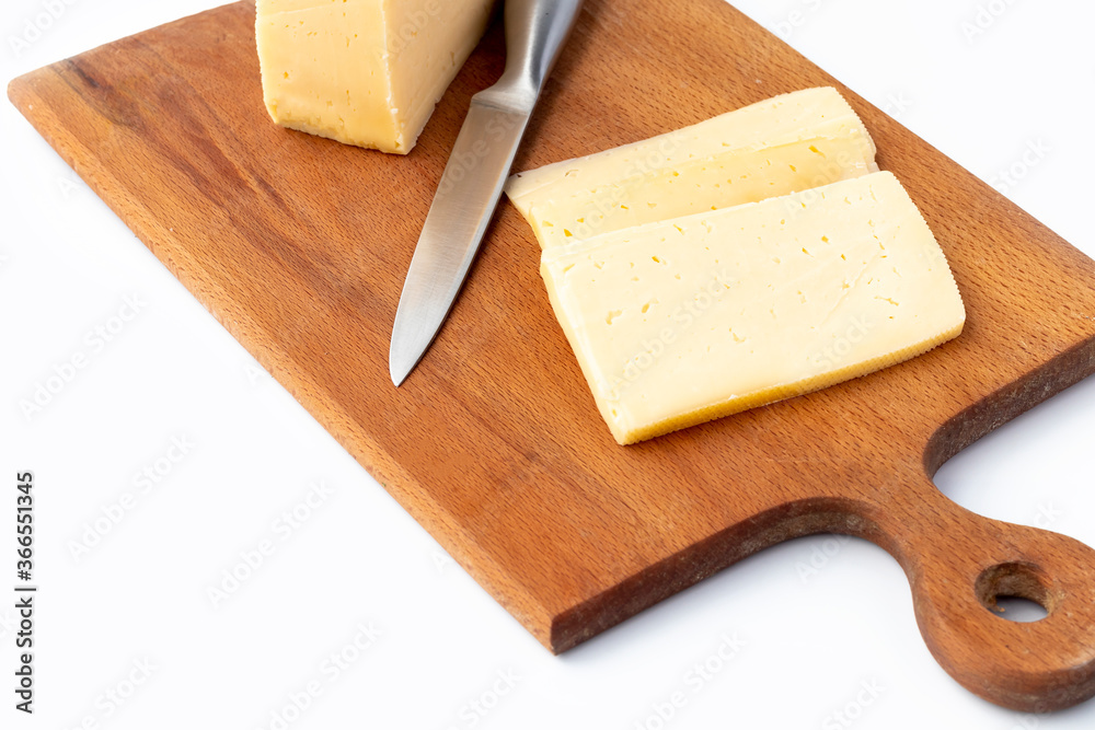 on a white background. No isolation. A small piece of cheese is cut into wedges. And a kitchen knife Close-up.