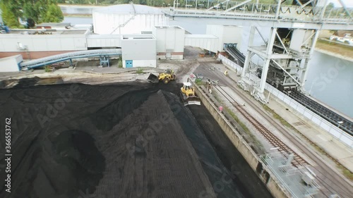 Drone flight over a big coal field at a european power plant with crane structures coming into view