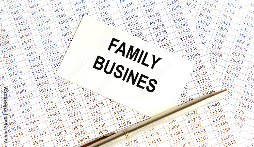Obraz premium On the white business card is the inscription FAMILY BUSINES, against the background of the buchgalster account and pen.