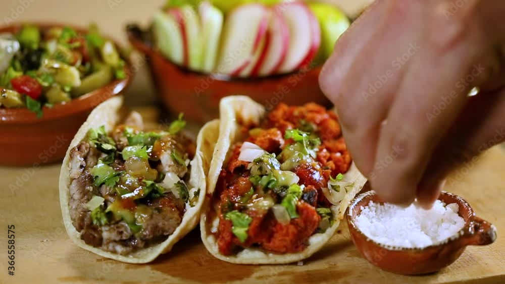 Man putting salt and lemon on his delicious tacos