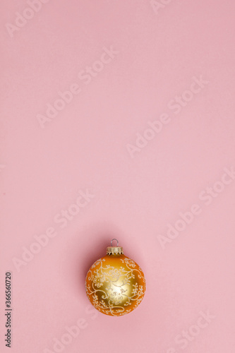 Gold Christmas ball on pink background. Flat lay