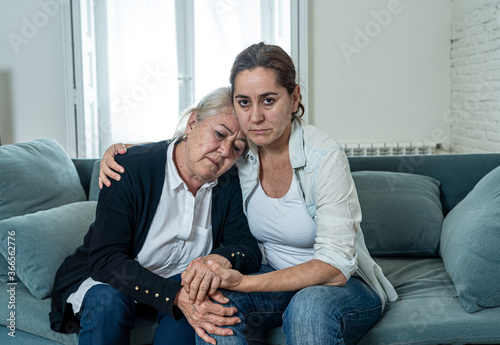 Fotografia Mother and daughter crying at home in quarantine grieving loss of family members