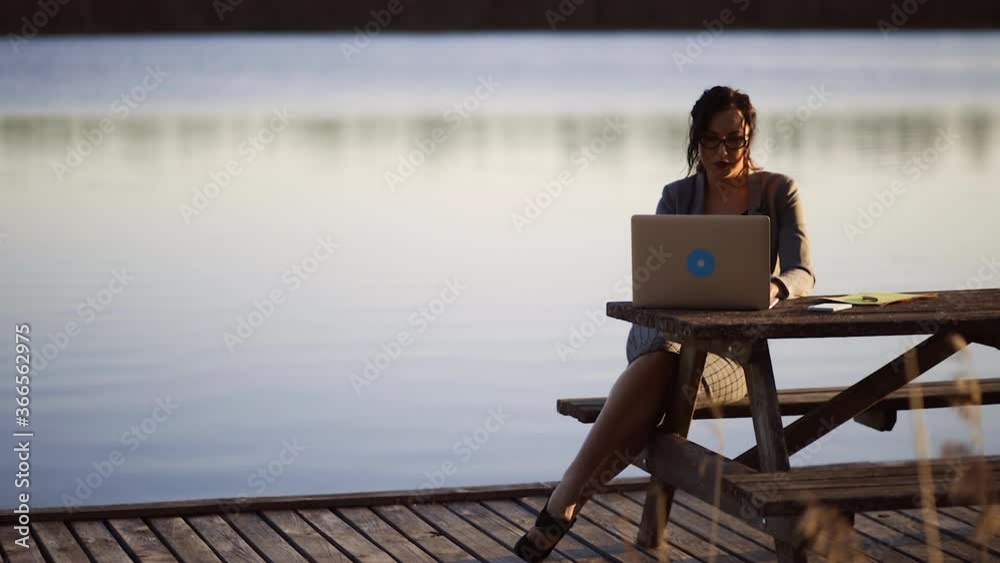 custom made wallpaper toronto digitalOrbit shot: Business woman in suit and high heels sits at wooden table, uses laptop for work and writes notes