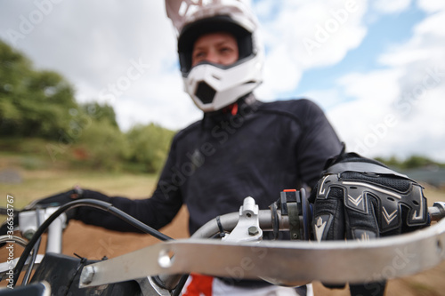 Close-up of motorcyclist pulling clutch in while preparing to ride off-road track © pressmaster