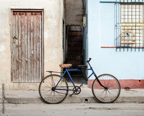 Canvas Print Blue bike bicycle in front of Cuban house with singing bird in cage, red and li