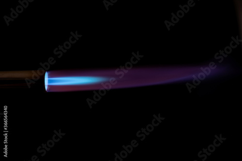 Gas burner with blue fire flame at black background photo
