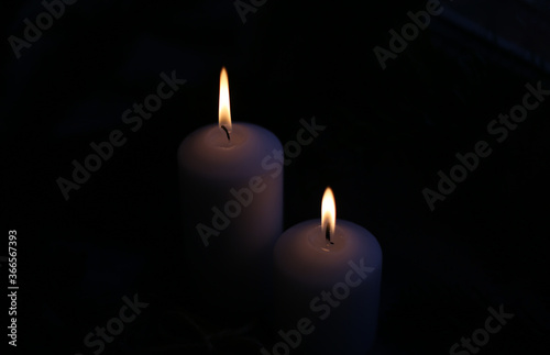 white candles in the darkness with fire