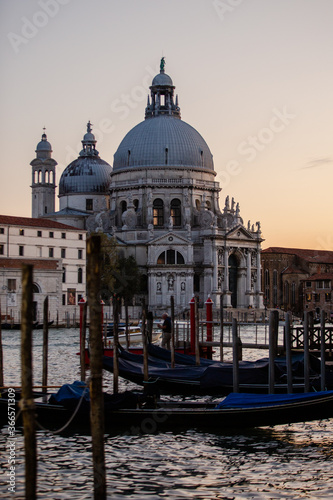 The Basilica di Santa Maria della Salute at dusk along the Venice docks with Gondola boats 