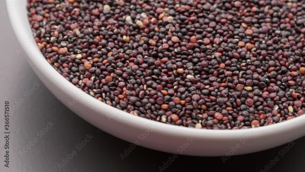 quinoa seeds in white bowl on dark background rotation. Top view. Macro quinoa seeds in white bowl on dark background rotation. Top view. Macro