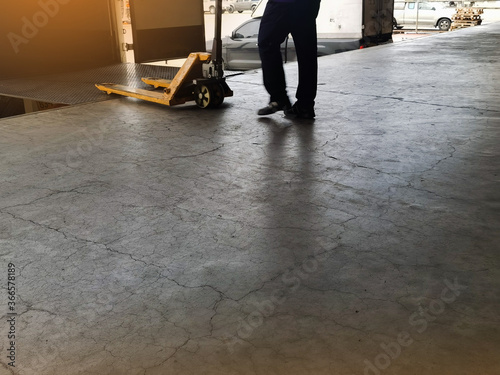 Worker driving forklift loading and unloading shipment carton boxes and goods on wooden pallet from container truck to warehouse cargo storage in logistics and transportation industrial 