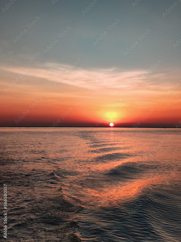 Naklejka premium Sunset is always magical. When sun dives into the mighty river Meghna , the moment is so spiritual to witness. A beautiful sunset in Bangladesh