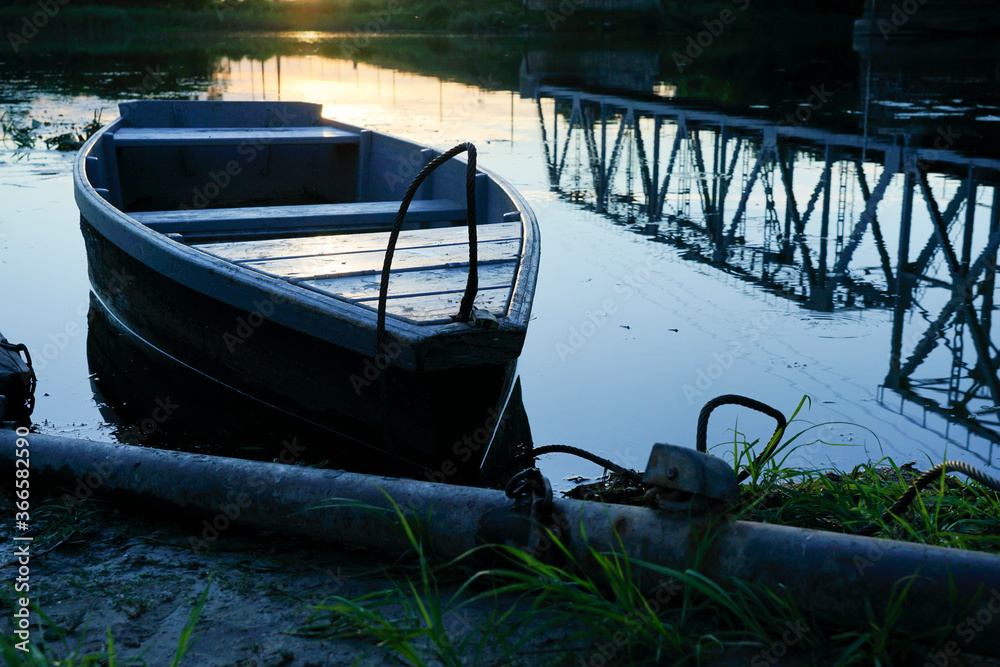 old wooden boats stand on the river in the evening