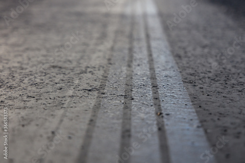 brake strips from a electric car, close-up shot on a hot asphalt road with reflecting clouds, burning wheels