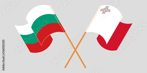 Crossed and waving flags of Malta and Bulgaria