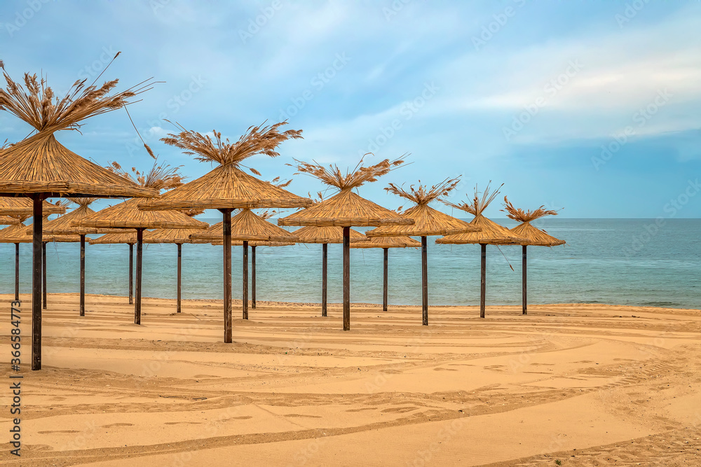Beauty wooden umbrellas of empty sandy beach