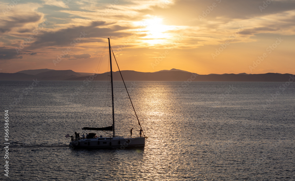Sailing at sunset, Boat on calm sea and orange sky background,