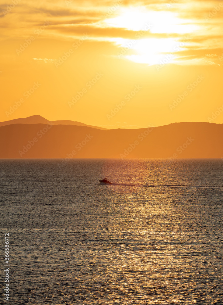 Sunrise, sunset clouds. Twilight, dusk cloudy sky over sea water, mountain silhouette