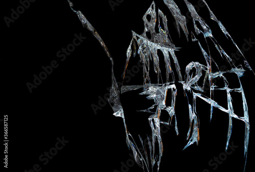 broken mirror glass on a black background in cracks in the form of an isolated image abstraction