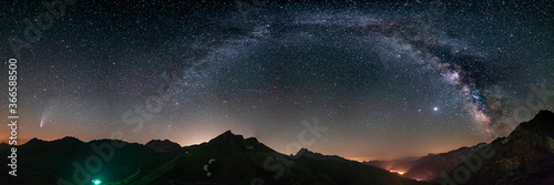 Milky Way arc and stars in night sky over the Alps. Outstanding Comet Neowise glowing at the horizon on the left. Panoramic view, astro photography, stargazing.