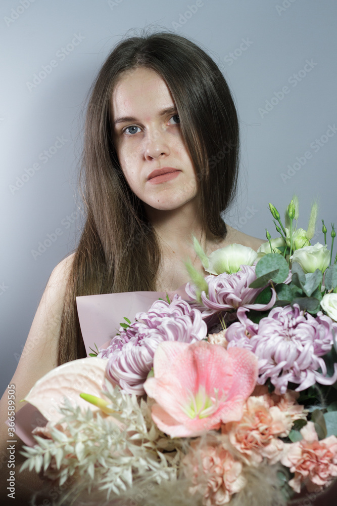 Portrait of long-haired brunette girl with beautiful summer bouquet, gift or congratulation concept, marriage proposal or engagement. Tenderness, beauty and romance concept. Portrait of long-haired brunette girl with beautiful summer bouquet, gift or congratulation concept, marriage proposal or engagement. Tenderness, beauty and romance concept.