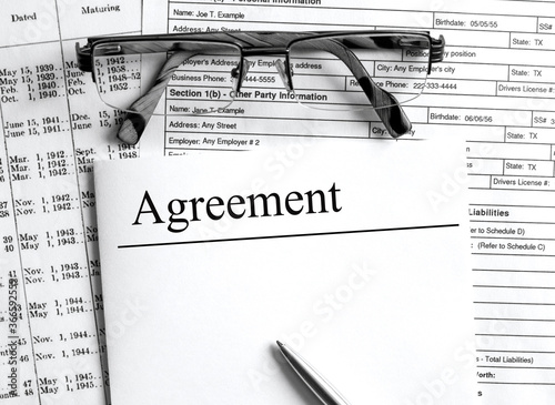 Paper with text Agreement on a financial tables with glasses