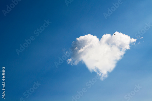 Heart shape made of white clouds against the blue sky