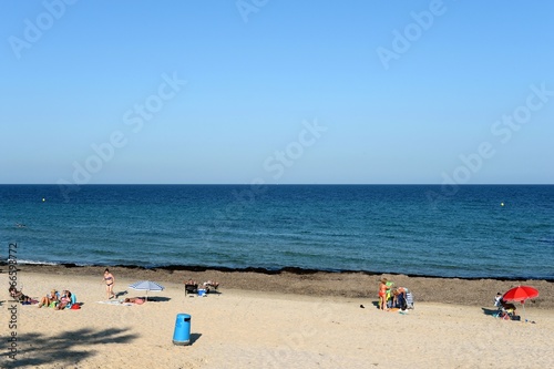 People relax on a sandy beach in Torre de La Horadada, Spain