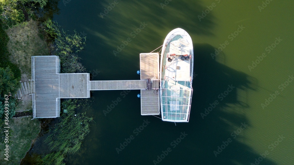 Fototapeta premium Aerial view of boat attached to the pier at the sunset