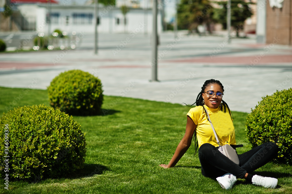 Portrait of  black African American woman in yellow t-shirt and glasses.