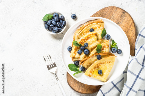 Crepes with blueberries at white table. photo