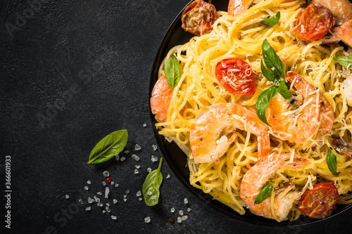 Pasta seafood with shrimp on black table.