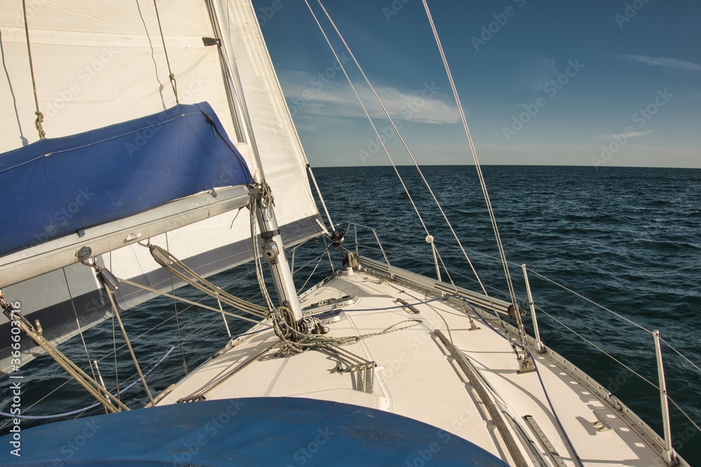 Fototapeta premium A sailing boat sailing upwind on a sunny bright calm day on the open sea.