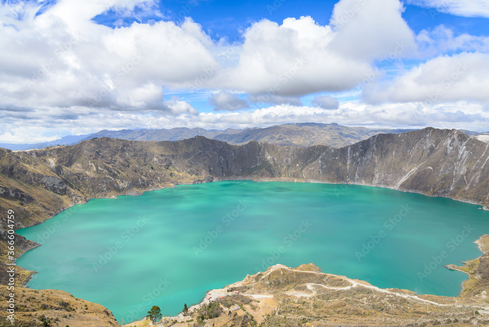 Quilotoa lagoon, Ecuador. This is water basin over the volcano crater. Blue sky and white clouds in the background