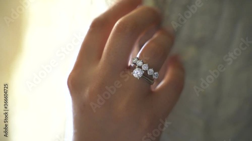 Getting diamond rings. closeup of diamond solitaire ring. cinematic close-up. Solitaire and five stone diamond rings in woman's hands photo