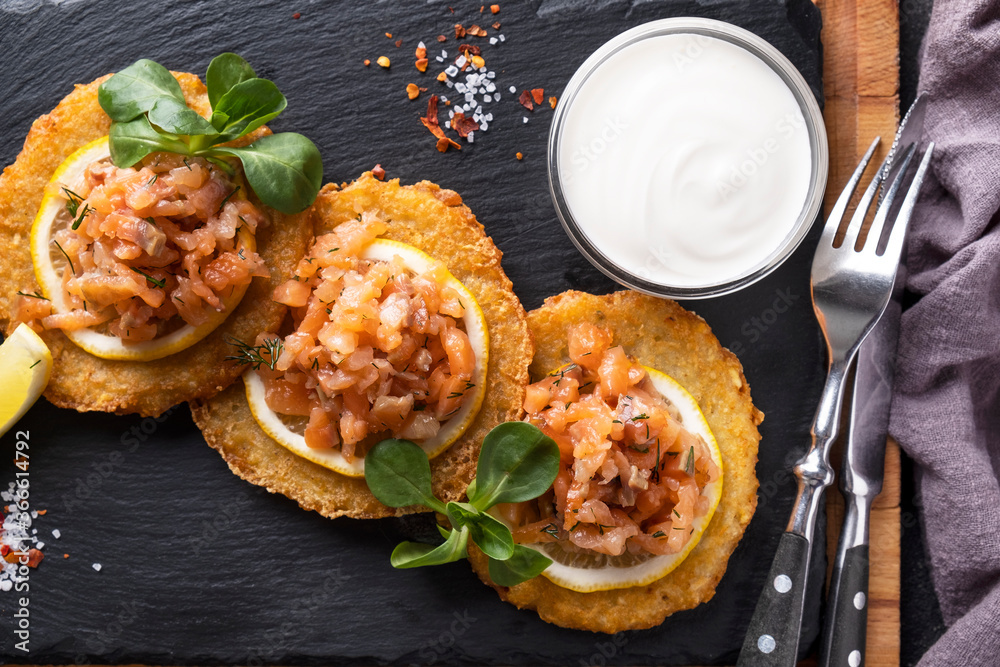Potato pancakes with salmon and sour cream. Draniki. Top view Potato pancakes with salmon and sour cream. Draniki. Top view
